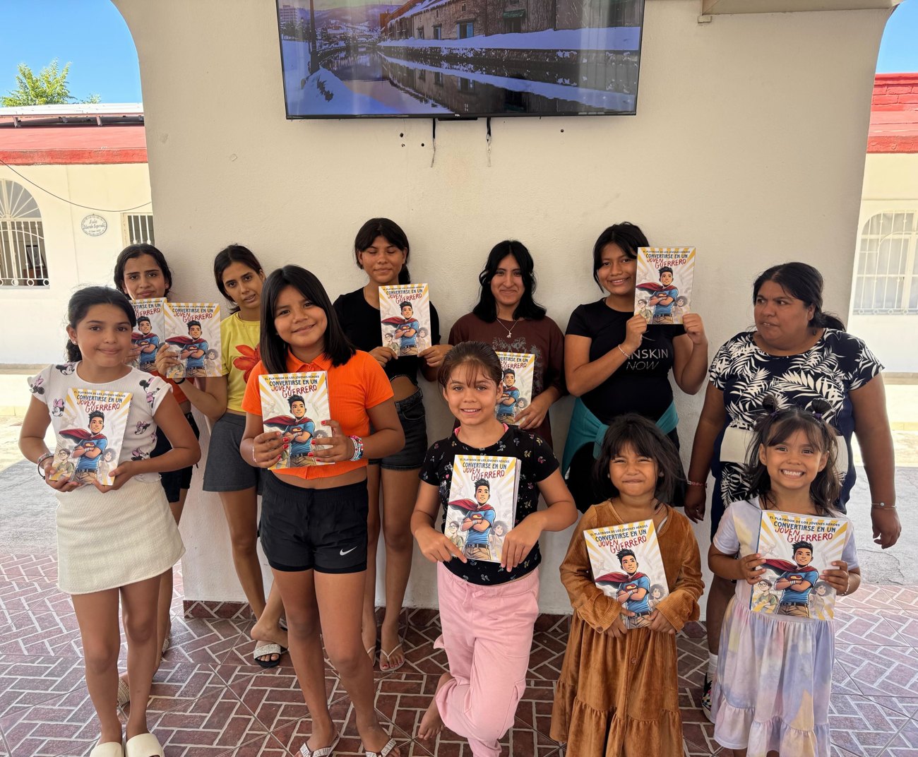 Girls at an orphanage in Jalisco, Mexico holding the Spanish Young Heroes Playbook, Convertirse en un Joven Guerrero